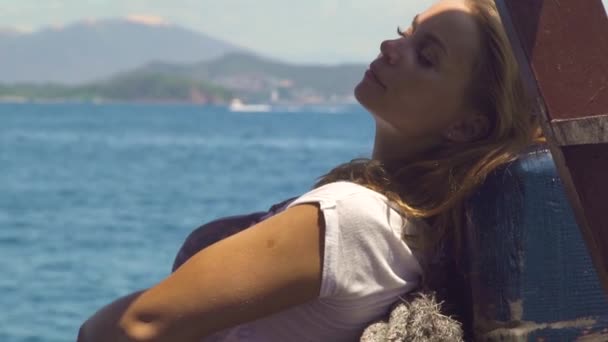 Schöne Frau entspannt sich auf einem Segelschiff auf der Meereslandschaft. junge Frau genießt das Segeln an Bord eines Seeschiffes. blauer Ozean und grüne Hügel Hintergrund. — Stockvideo