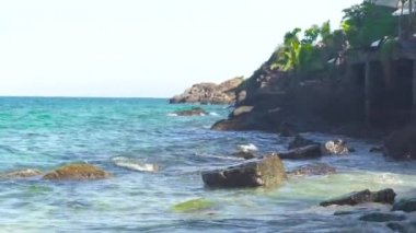 Taşlı plaja ve kayalık ada sıçramasına dalgalar deniz. Dalgalar okyanusta kayalık plaj kırma. Mavi deniz suyu ve büyük taşlar manzara.