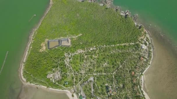 Île verte avec hôtel de villégiature et plage de sable en vue aérienne sur la mer. Paysage de l'île tropicale de drone volant avec palmier sur la côte de l'océan . — Video