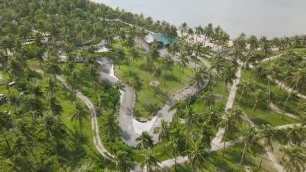 Luchtfoto karten circuit onder palmbomen op een tropisch eiland in zee. Drone weergave circuit voor het karten in luxeresort aan de kust en zee landschap. — Stockvideo