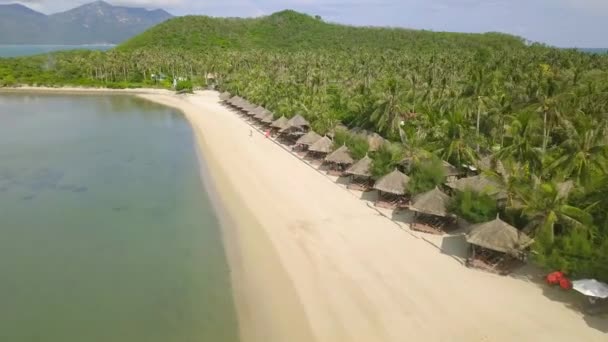 Бунгало стоячи в рядку на райському острові з білим піском на березі повітряних видом на океан. Розкішний курорт пляж на зелений тропічний острів на морський краєвид, drone подання. — стокове відео