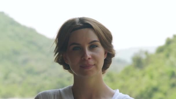 Retrato joven mujer verde paisaje de montaña en el día de verano. Cara chica mirando en cámara en montaña cubierto verde bosque fondo . — Vídeo de stock