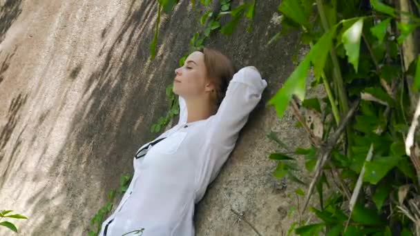 Mulher feliz descansando magra de volta na montanha no dia de verão. Menina relaxante inclinando-se para trás na pedra grande e desfrutar do dia de verão . — Vídeo de Stock