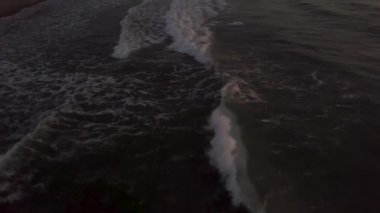 Sabah erken gündoğumu sırasında kumsalda deniz su dalgaları üzerinde uçan uçak. Abovewater dalgalar okyanus plaj akşam günbatımı sırasında sıçramasına gelen hava manzara.