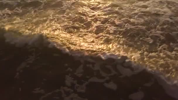 Ondas de água do mar na praia de areia, enquanto o nascer do sol dourado na manhã de verão. Drone vista belo pôr do sol no céu da noite refletindo na água do mar. Paisagem aeial madrugada na praia oceânica . — Vídeo de Stock