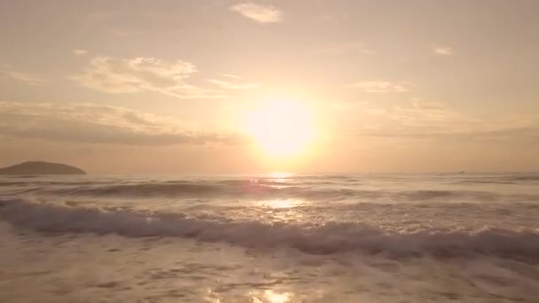 Sol dorado en el cielo colorido al atardecer y salpicaduras de olas de agua en el mar, vista al dron. Paisaje aéreo amanecer temprano en el cielo de la mañana sobre el agua de mar en la playa de verano  . — Vídeo de stock