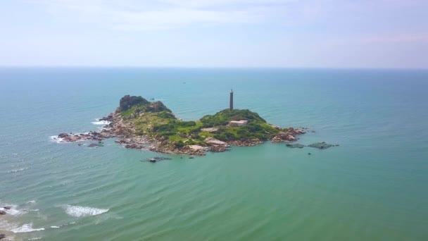 青い海航空風景で岩だらけの島の灯台。岩の島海と青のスカイラインの風景のドローン ビュー光の家. — ストック動画