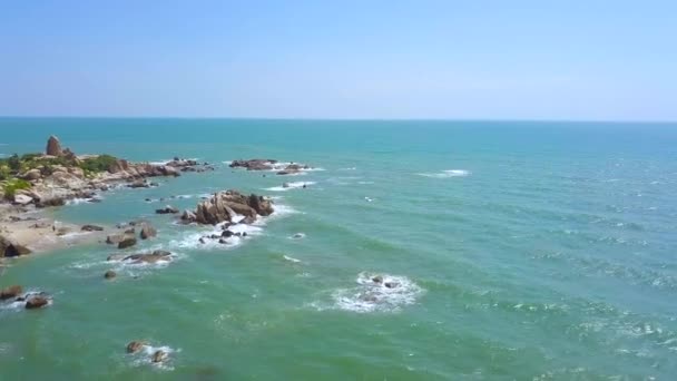 Cliff eiland in de blauwe zee en spetterend water golven landschap van drone vliegen. Rotsachtig eiland in de blauwe oceaan water en skyline luchtfoto. — Stockvideo