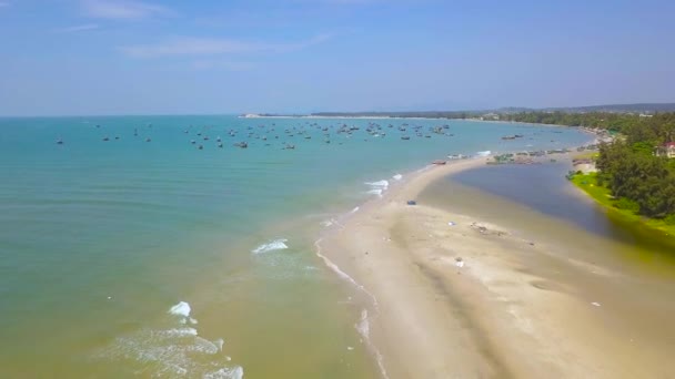 Морской берег и палубный корабль на стоянке с видом на море. Беспилотник летит над морским побережьем и корабли в голубой воде у берега . — стоковое видео