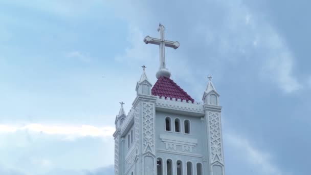 Katolicki krzyż na szczycie wieży katedry katolickiej. Religijne cross wieża kościoła katolickiego na tle zachmurzone niebo. Antyczny architektura religijnym gmach w stylu gotyckim. — Wideo stockowe