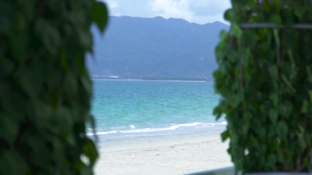 Blaues Meer am Sommerstrand, Berg- und grüne tropische Pflanzenlandschaft. Sommerstrand und grüne Pflanzen auf blauem Meer und Berglandschaft. — Stockvideo