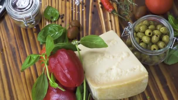 Papriky, olivy, rajčata, sýr, cibuli, česnek a koření k vaření na kuchyňském stole. Detailní záběr hotovky zeleninu, sýr, koření, olivový olej pro přípravu potravin. — Stock video