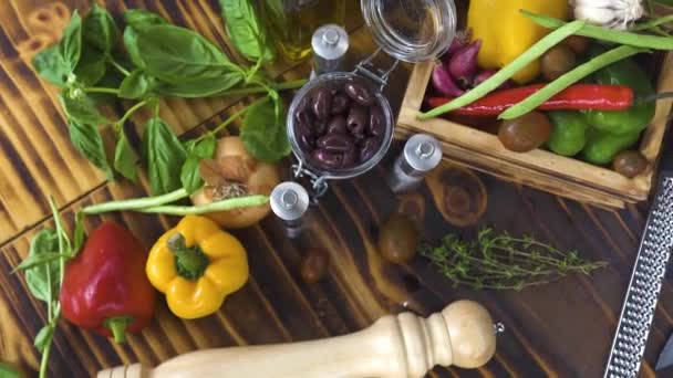 在厨房桌子上有五颜六色的蔬菜背景。新鲜蔬菜, 橄榄, 面食烹饪调味料。用于食品制备的成分。健康的营养和饮食。蔬菜成分跟踪镜头 — 图库视频影像