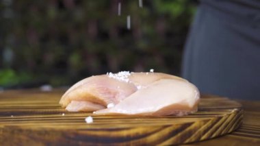 Ahşap masa üzerinde ham taze tavuk fileto et kapatın. Tavuk göğsü mutfak gemide yalan üzerine dökülen tuz. Işlem hazırlama sağlıklı gıda. Fitness Gıda ve protein diyet. Et yemek pişirme.