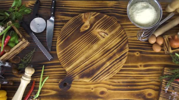 Mesa de madera con verduras y alimentos para cocinar vista superior. Filete de pollo crudo que cae sobre tabla de madera para cocinar. Carne de pollo, verduras, huevos, harina y utensilios de cocina . — Vídeos de Stock