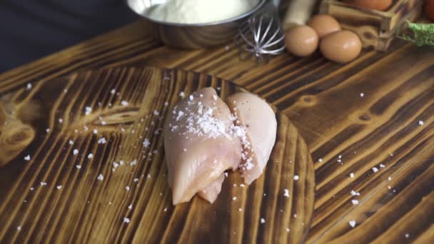 Filetto di pollo fresco, sale e pepe nero su fondo di legno. Pepe nero versato sul filetto di pollo crudo. Condimento per carne. Processo di cottura cibo sano. Cibo di preparazione su cucina . — Video Stock