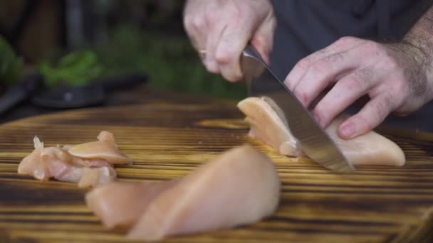 Chef cozinheiro corte de filé de frango cru com faca na mesa de madeira. Mão masculina corte em fatias de carne de frango. Preparação do processo comida saudável. Nutrição de proteínas e dieta fitness. Cozinhar conceito de comida . — Vídeo de Stock