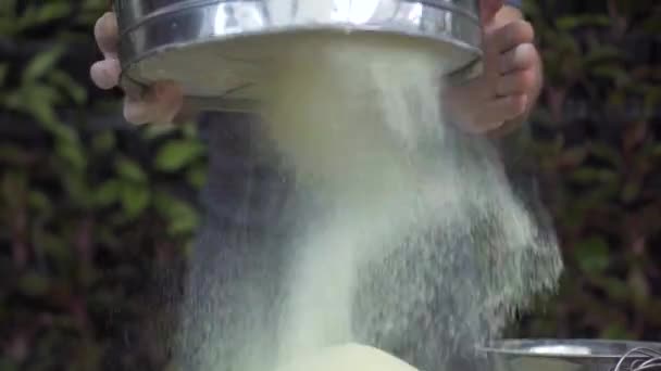 Baker gebogen bloem poeder door zeef voor het bakken van slow-motion. Chef-kok koken hand zeven bloem op tafel met zeefstel in bakkerij keuken. Voorbereiding ingrediënten voor het bakken. Koken deeg concept. — Stockvideo