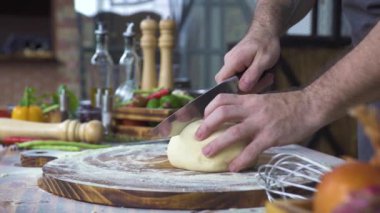 Şef aşçı kesme hamur pasta pişirme için bıçak ile kapatın. Ahşap masa üzerinde haddeleme için hamur Dilimleme Baker. Işlem hazırlama ev yapımı hamur işi. Pişirme fırın ürünleri, makarna, pizza, gıda kavramı.