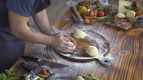 Manos masculinas haciendo masa para hornear pasteles. Chef cocinar amasar masa para la preparación de pizza en tablero de madera. Cocinar pastelería casera en la cocina de panadería. Preparación pasta, espaguetis, concepto de comida . — Vídeo de stock