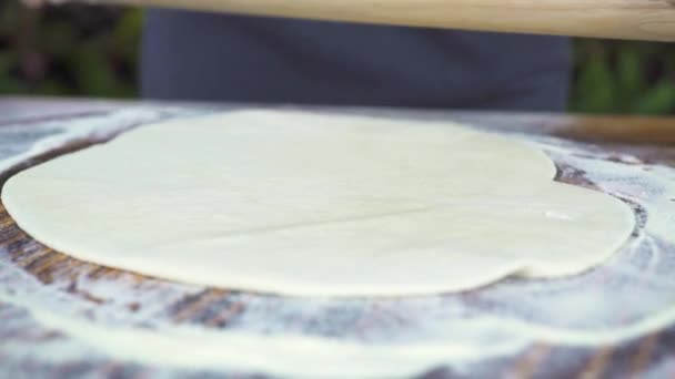 Baker massa rolante com rolo para assar bolo na cozinha da padaria. Fecha a porta. Chef cozinhar massa de pizza rolando com rolo de madeira. Bolo de pastelaria na padaria. Cozinhar comida, gastronomia, conceito culinário . — Vídeo de Stock