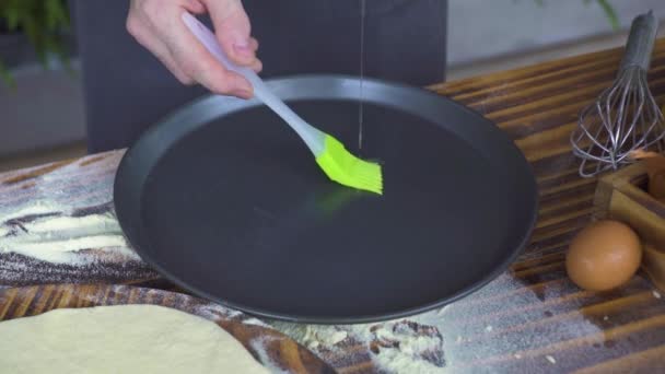 Chef cozinheiro derramando azeite na assadeira e espalhando com escova na mesa da cozinha. Azeite de torta de cozedura, bolo, pizza na bandeja no forno de padaria. Pastelaria de preparação de processo. Cozinhar conceito de comida . — Vídeo de Stock