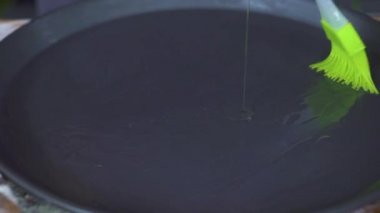 Tepsi fırın ve mutfak masasının üzerinde fırça ile yayılan dökme zeytinyağı yemek. Zeytin yağı kızartma yemek zor durumda kapatın. İşlem hazırlık akşam yemeği ev mutfak.