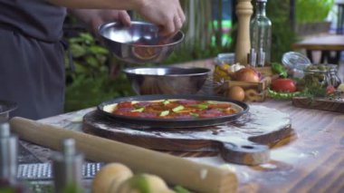 Şef sosis ve domates mutfak masasında, gıda arka plan hazırlama pizza yemek. İtalyan pizzaillo içinde pizzacı pizza yapma. Geleneksel İtalyan yemeği pişirme işlemi. Yemek hazırlamak kavramı