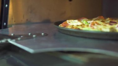Alarak Pizzaillo pizza üzerinde mutfak kürek gelen pizzacı sıcak fırında pişirilir. Modern restoranda soba hazırlanan gevrek kabuk iştah açıcı İtalyan pizza. Profesyonel Aşçılık Ulusal Gıda.