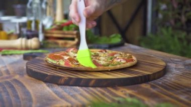 Pizzaillo zeytinyağı gevrek kabuk mutfak masasının üzerinde sıcak pizza yayılıyor. Şef yemek İtalyan pizza pizzacı mutfakta yapma. Işlem hazırlama ve yemek servisi. Geleneksel İtalyan mutfağı, yemek