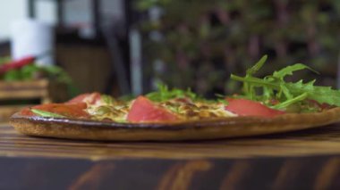 Taze otlar sıcak İtalyan pizza yavaş hareket üzerinde düşüyor. Pizza pizza taze otlar ile kapatın. Gıda baharat kavramı. Geleneksel yemek pişirme. Ulusal İtalyan mutfağı.