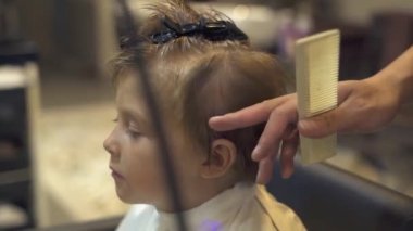 Kuaför Güzellik salonunda kesme çocuk iken küçük çocuk saç kurutma. Çocuk saç kurutma makinesi ile berber dükkanı üfleme Kuaför kapatın. Çocuk saç modeli yapmak Kuaför saç kesimi.