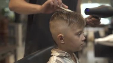 Çocuk saç modeli ile berber dükkanı kurutucuya. Çocuk saç kurutma Kuaför Salonu. Kuaför styling saç kurutma makinesi ile küçük çocuk. Kuaförler Berber Dükkanı olarak bitirmek. Çocuk saç modeli kavramı.