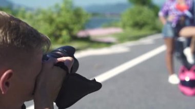 Erkek fotoğrafçı fotoğrafçılık genç kadın ile Motosiklet açık poz alarak. Genç adam fotoğrafçı profesyonel modeli ile çalışma. Fotoğraf makinesi fotoğraf oturumu için kullanan adam.