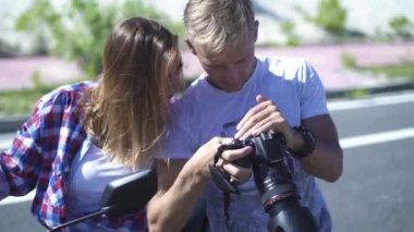Kadın foto model ve fotoğrafçı fotoğraf fotoğraf oturumu sırasında kameraya bakıyor. Resimleri izlerken fotoğrafçı ve Genç manken. Erkek ve kadın video izlemek için fotoğraf makinesi kullanma.