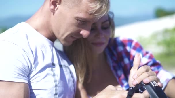 Fotógrafo y modelo mujer buscando foto en la cámara de fotos durante la sesión de fotos. Joven modelo de moda y fotógrafo viendo fotos. Hombre y mujer utilizando la cámara para ver vídeo . — Vídeo de stock