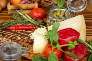 Peynir, biber, yeşil zeytin, domates ve baharat kadar kapatın. Gıda arka plan, sebze kompozisyon. Taze malzemelerle hazırlık salata, pizza, makarna ahşap masa üzerine. Sağlıklı bir diyet ve beslenme.