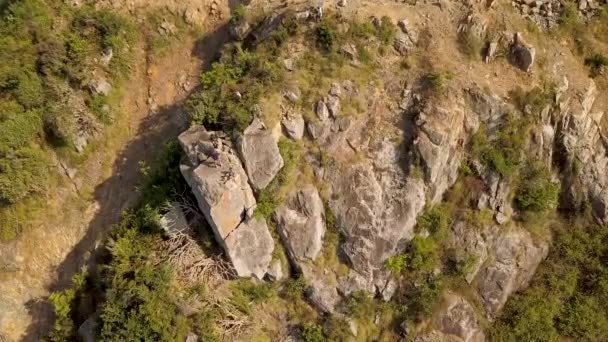 Pessoas de turismo em pé no pico da montanha vista aérea. Caminhantes na borda do penhasco enquanto viajam na montanha. Vista superior de alpinistas de drones voadores no pico do penhasco . — Vídeo de Stock