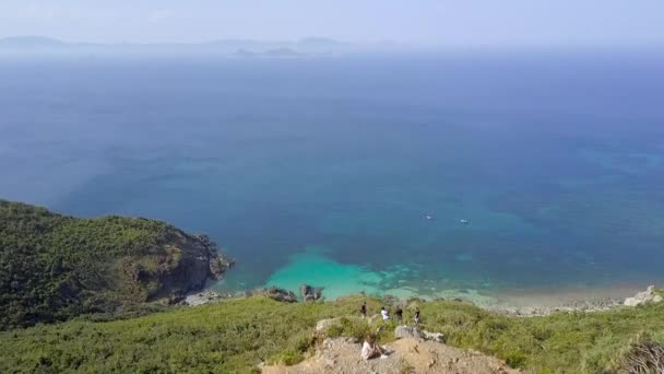 Letecká krajina turista na vrchol hory nad modré moře na obzoru. DRONY pohled z okraje útesu na tyrkysovou mořskou vodu. Modrá oceán krajina od vrchol hory. — Stock video