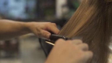 Berber Kuaför Salon saç şekillendirme sırasında saç düzleştirme için saç demir kullanarak. Profesyonel Studio kadın saç şekillendirme kapatın. Kuaför Berber içinde kadın saç modeli oluşturma.