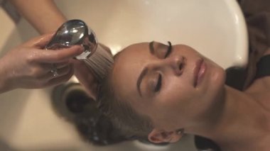 Güzel kadın saç şampuanı Kuaför Salon ile yıkarken yüz. Genç kadın baş güzellik salonunda yıkama alıyorum. Saç Bakımı ve güzellik
