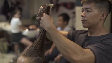 Asyalı erkek kuaförü penye ve kesim saç Güzellik Studio kadın saç kesimi ise ıslak. Kuaför berber dükkanı kesme genç kadında. Kadın saç kesimi kavramı. Güzellik ve bakım.