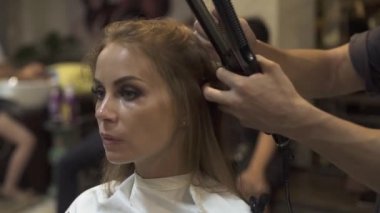 Penye ve Kuaför Salonu saç demir saç düzleştirme kuaförlük. Kuaför berber dükkanı olarak sıcak maşa ile kadın saç modeli yapmak. Güzellik ve stil kavramı.