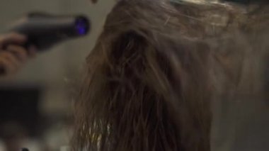 Güzellik Salonu yıkama sonrası uzun saç kurutma makinesi ile kurutma. Kuaför berber dükkanı olarak kadın saç şekillendirme sırasında ıslak saç kurutma. Profesyonel saç modeli. Güzellik ve bakım kavramı.