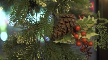 Yeşil koni ile Noel ağacı dalları ve cam pencere üzerinde kırmızı meyveler kapatın. Yeni yıl dekorasyon köknar çelenk, koni ve kutlama tatil için kırmızı meyveler. Noel dekorasyon konsepti.
