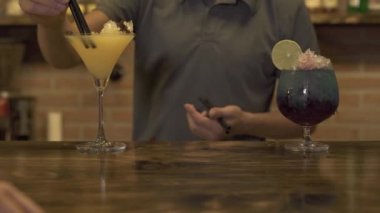 Barmen alkollü kokteyl bar sayacı kırılmış buz ile kafede yapma. Uzun bir içki kokteyl cam masa pub bar buz ile saman ekleyerek barmen.