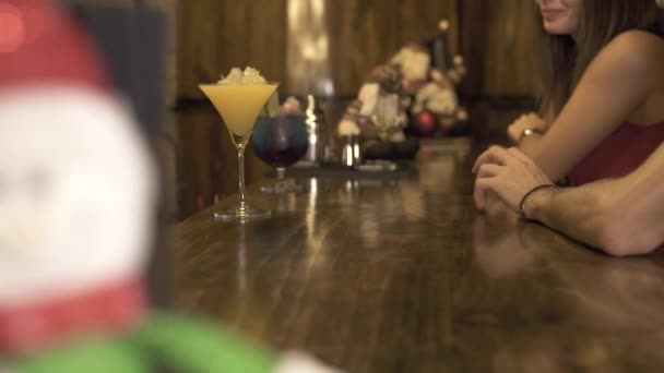 Barman decoración cóctel en la mesa del bar para la fiesta en el pub. Cantinero haciendo cóctel alcohólico para el cliente sentado en el mostrador del bar en la cafetería de la noche. Pareja joven en restaurante esperando bebida . — Vídeo de stock