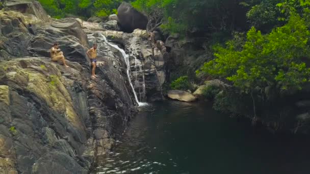 人在山瀑布潜水在热带森林鸟图 人们在瀑布河中潜水和游泳 在山区和热带雨林无人机景观 — 图库视频影像