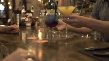 Barmen, alkollü kokteyl bar tablo istemci için akşam kafede koyarak. Uzun bir içki kokteyl cam sayacı Restoran, bar, oturma alan insanlar.