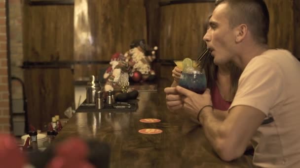 Genç adam ve kadın bar counter alkollü kokteyl barda içki. Restoranda romantik tarih sırasında tablo kokteyl içme çift. — Stok video